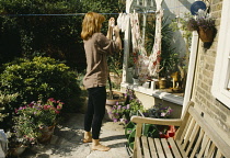 England, London, woman hanging out washing.