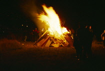 Festivals, Guy Fawkes, Family group standing in front of blazing bonfire.