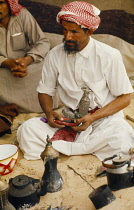 Qatar, General, Seated Bedouin man in camp.