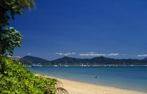 Australia, Queensland, Great Barrier Reef, Dunk Island view over empty beach towards sea with hills in the distance.