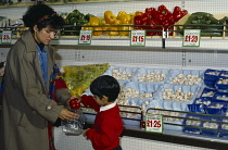 Shopping, Supermarkets, Interior, Woman with her young son shopping for vegetables.