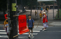 Australia, NSW, Sydney, Lolly pop lady shows children accross zebra crossing outside Globe Primary School.