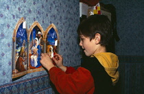 Religion, Christianity, Boy opening the windows on an Advent Calendar.