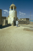 Qatar, Khor, Man on the roof of the old mosque in the fishing village, The roof has a layer of small shells to keep it cool.