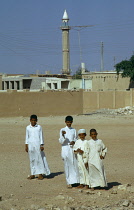 Qatar, Khor, Boys in the fishing village standing in front of the mosque.