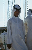 Qatar, Doha, Portrait of a boy in traditional clothes and head-dress.