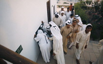 Qatar, Doha, Crowds of men at Doha Museum.