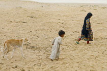 Qatar, Desert, Bedouin children, Girl and young boy with Saluki dog.
