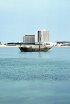 Qatar, Doha, Gulf hotel with dhow in foreground.
