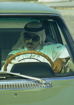 Qatar, People, Man wearing sunglasses sat behind wheel of car.