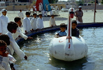 Qatar, Doha, Children playing on water ride.