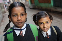 India, Uttar Pradesh, Varanasi, Portrait of two school girls with tika marks.