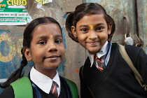 India, Uttar Pradesh, Varanasi, Portrait of two school girls with tika marks.