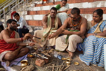 India, Uttar Pradesh, Varanasi, A pundit performs a puja for a bereaved family at Kedar Ghat.