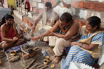 India, Uttar Pradesh, Varanasi, A pundit performs a puja for a bereaved family at Kedar Ghat.