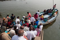India, Uttar Pradesh, Varanasi, Pilgrims board a boat on the River Ganges.