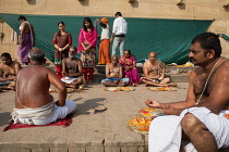 India, Uttar Pradesh, Varanasi, A bereaved family participate in a puja for a deceased relative on the ghats.