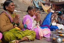 India, Uttar Pradesh, Varanasi, Hindi women praying on the ghats beside the River Ganges.