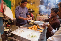 India, Uttar Pradesh, Varanasi, A food hotel serving idlis & dahl vada in the old city.