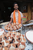India, Uttar Pradesh, Allahabad, A vendor selling mishti doi sweet curd in clay pots at a food hotel.