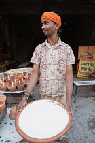 India, Uttar Pradesh, Allahabad, A vendor selling mishti doi sweet curd at a food hotel.