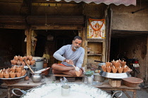India, Uttar Pradesh, Allahabad, A vendor selling mishti doi sweet curd at a food hotel.