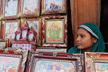 India, Uttar Pradesh, Ayodhya, Woman selling pictures of hindu gods and deities in the market.