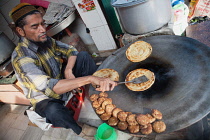 India, Uttar Pradesh, Faizabad, A muslim cook frying parathas.