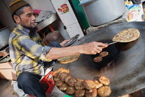 India, Uttar Pradesh, Faizabad, A muslim cook frying parathas & mutton patties.