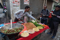 India, Uttar Pradesh, Lucknow, A vendor prepares a vegetarian snack including mung bean sprouts at his road-side stall.