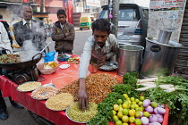 India, Uttar Pradesh, Lucknow, A vendor prepares a vegetarian snack including mung bean srouts at his road-side stall.