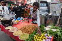 India, Uttar Pradesh, Lucknow, A vendor prepares a vegetarian snack including mung bean srouts at his road-side stall.