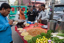 India, Uttar Pradesh, Lucknow, A vendor prepares a vegetarian snack including mung bean srouts at his road-side stall.