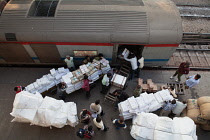 India, New Delhi, Porters loading baggage into the goods carriage of an express train at Railway Station.