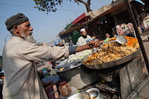 India, New Delhi, A muslim man cooking chicken biryani in the old city of Delhi.