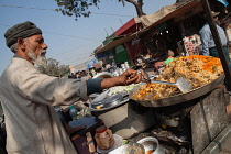 India, New Delhi, A muslim man cooking chicken biryani in the old city of Delhi.