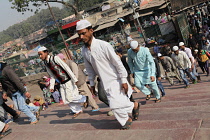 India, New Delhi, Muslim men walking up the steps to the Jama Masjid for afternoon prayers.