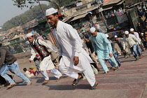India, New Delhi, Muslim men walking up the steps to the Jama Masjid for afternoon prayers.