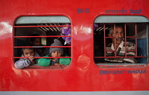 India, New Delhi, Passengers look out of a train carriage window at Delhi Junction railway station.