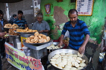 India, New Delhi, A cook making kachori at a street stall in the old city of Delhi.