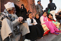 India, New Delhi, Muslim girls sit on the steps in front of the entrance to the Jama Masjid in the old city of Delhi.