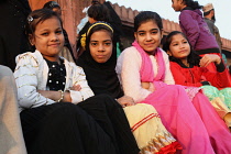 India, New Delhi, Muslim girls sit on the steps in front of the entrance to the Jama Masjid in the old city of Delhi.