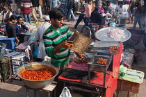 India, New Delhi, A food vendor grilling kebabs in the cotton market in the old city of Delhi.