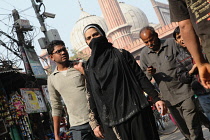 India, New Delhi, A muslim woman walks through the streets of the old city of Delhi in front of the Jama Masjid.
