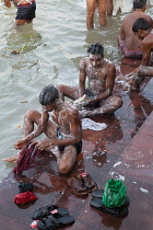 India, West Bengal, Kolkata, Men wash and bathe in the Hooghly River at Malik Ghat.