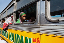 India, West Bengal, Kolkata, A passenger at the window of a public bus.