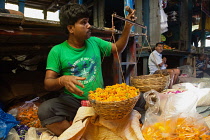 India, West Bengal, Kolkata, Vendor at Malik Ghat Flower Market.