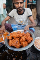 India, West Bengal, Kolkata, A man cooks chicken pakora on the street.