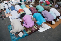 India, West Bengal, Kolkata, Muslim men at prayer on MG Road.