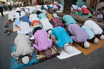 India, West Bengal, Kolkata, Muslim men at prayer on MG Road.